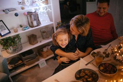 Man and woman and young girl at a table at Christmas