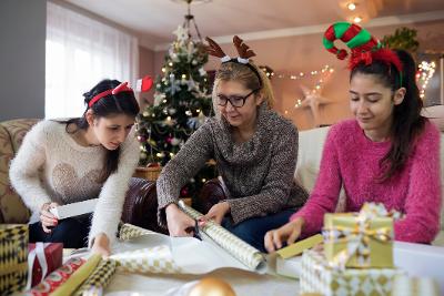 Woman and two teenagers wrapping gifts