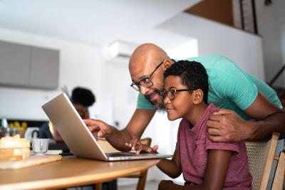 Man helping young man with a laptop what are