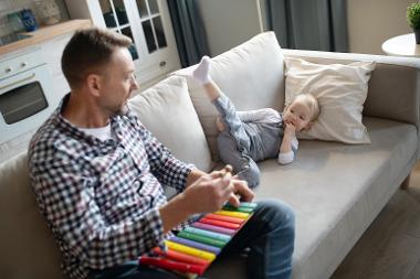 Man on sofa with musical instrument and young boy