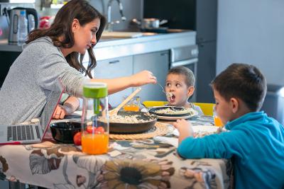 Woman at dining table with two young boys