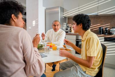 Male adult and teen male and woman eating at table