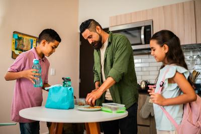 Dad serving food to two children 